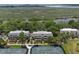 Expansive aerial view showcases townhomes with lush landscaping and tennis courts, nestled near a scenic marshland area at 1627 Live Oak Park, Seabrook Island, SC 29455