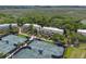 Scenic aerial showcases tennis courts near residential townhomes with balconies and verdant landscaping in marshland waterfront community at 1627 Live Oak Park, Seabrook Island, SC 29455