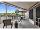 Cozy balcony featuring outdoor seating, a table with umbrella, and views of the tennis courts and lush greenery at 1627 Live Oak Park, Seabrook Island, SC 29455