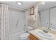 Well-lit bathroom featuring a shower-tub combination with beach themed shower curtain and vanity with integrated sink at 1627 Live Oak Park, Seabrook Island, SC 29455