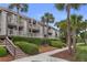 Charming condo exterior with multiple balconies, lush landscaping, and inviting stairs leading to upper units at 1627 Live Oak Park, Seabrook Island, SC 29455