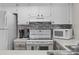 Well-equipped kitchen with white cabinetry, modern appliances, and mosaic tile backsplash at 1627 Live Oak Park, Seabrook Island, SC 29455