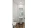 Modern half bathroom with pedestal sink, toilet, and hardwood floors at 174 Red Bluff St, Summerville, SC 29483