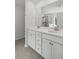 Bright bathroom featuring double sinks, white cabinetry, tile flooring, and a glass shower with a tile surround at 174 Red Bluff St, Summerville, SC 29483