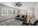 Living room with many windows and view of bright kitchen, hardwood floors and stylish rug at 174 Red Bluff St, Summerville, SC 29483