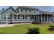 Backyard featuring green lawn, garden and screened-in porch of the home with white trim and green siding at 183 Calm Water Way, Summerville, SC 29486