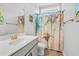Well-lit bathroom with a single sink, palm tree shower curtain, and tile flooring at 183 Calm Water Way, Summerville, SC 29486