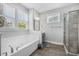 Bright bathroom featuring a soaking tub under a window, separate shower, and gray walls at 183 Calm Water Way, Summerville, SC 29486