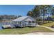 A covered dock with a wooden platform on a serene lake provides a tranquil spot for relaxation near the walking path at 183 Calm Water Way, Summerville, SC 29486