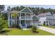 Inviting two-story home with a charming porch, lush lawn, and a well-manicured landscape at 183 Calm Water Way, Summerville, SC 29486