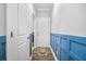 Hallway with blue wainscoting, hardwood floors, and white doors at 183 Calm Water Way, Summerville, SC 29486
