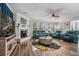 Bright living room featuring teal leather furniture, fireplace, ceiling fan, and wood flooring at 183 Calm Water Way, Summerville, SC 29486