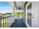Covered porch featuring wood-look floors, white railings, and exterior green siding at 183 Calm Water Way, Summerville, SC 29486