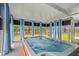 Relaxing spa area with a large hot tub surrounded by windows and blue striped curtains, offering a serene view of the outdoors at 183 Calm Water Way, Summerville, SC 29486