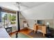 Well-lit bedroom with hardwood floors, ceiling fan, desk, and large windows with views of the outdoors at 19 Avondale Ave, Charleston, SC 29407