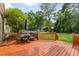 Outdoor deck with table, chairs, and an umbrella overlooking a beautiful green yard with playground at 19 Avondale Ave, Charleston, SC 29407