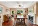 Well-lit dining room featuring hardwood floors, fireplace, and backyard views at 19 Avondale Ave, Charleston, SC 29407