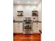 Professional stainless steel range with white cabinets and shelving with black countertop at 19 Avondale Ave, Charleston, SC 29407