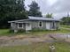 A gray block home with a metal roof, small yard, and two entry doors at 2200 State Road Rd, Summerville, SC 29486