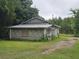 Rustic cinder block home exterior with a metal roof surrounded by lush greenery at 2200 State Road Rd, Summerville, SC 29486