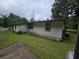 Exterior side view of the house with white siding, lawn, and mature trees in the background at 2200 State Road Rd, Summerville, SC 29486