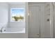Bright bathroom with tub under window and glass-enclosed shower at 226 Seele St, Summerville, SC 29485