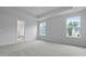 Bright main bedroom with carpet, neutral walls, tray ceiling, and an ensuite bathroom, perfect for relaxation at 226 Seele St, Summerville, SC 29485