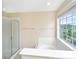 Bright bathroom featuring a tub, shower, and window overlooking outside at 2301 N Creek Dr, Mount Pleasant, SC 29466