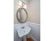 Bathroom featuring a pedestal sink, decorative mirror, and wainscoting at 2301 N Creek Dr, Mount Pleasant, SC 29466