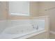 Bathroom showcasing a large soaking tub with tile surround and a window at 2301 N Creek Dr, Mount Pleasant, SC 29466