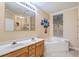 Well-lit bathroom features a dual sink vanity and a jetted tub at 2393 Folly Rd # 1G, Folly Beach, SC 29439
