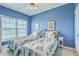 Blue bedroom with twin beds, ceiling fan, and natural light at 2393 Folly Rd # 1G, Folly Beach, SC 29439