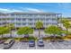 Three-story condo building featuring private balconies, covered parking, and professional landscaping at 2393 Folly Rd # 1G, Folly Beach, SC 29439