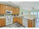 Functional kitchen with a range, microwave, dishwasher and wood-toned cabinetry at 2393 Folly Rd # 1G, Folly Beach, SC 29439