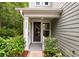 Charming home entrance featuring a black front door, white columns, and lush landscaping at 2688 Jacana Ct, Mount Pleasant, SC 29466