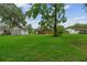 Spacious backyard featuring lush green grass and mature trees behind the home at 2708 Mawood Ave, North Charleston, SC 29406