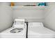 Bright laundry room featuring white washer and dryer with storage shelf at 291 Sea Cloud Cir, Edisto Beach, SC 29438