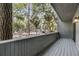 Exterior view from the wooden patio showing lush trees and parking at 291 Sea Cloud Cir, Edisto Beach, SC 29438