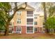 Three-story condo building featuring private screened balconies and views of lush landscaping and mature trees at 300 Bucksley Ln # 102, Charleston, SC 29492