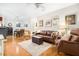 Open-concept living room and dining area featuring hardwood floors, a leather sofa, and wicker furniture at 300 Bucksley Ln # 102, Charleston, SC 29492