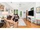 Comfortable living room with hardwood floors, a leather sofa, and a balcony door letting in natural light at 300 Bucksley Ln # 102, Charleston, SC 29492