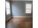 Sunny bedroom features hardwood floors, neutral walls and two bright windows at 301 Ridge St, Saint George, SC 29477