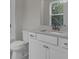 Bathroom with white cabinets, neutral countertop, toilet, and a mirror, offering functionality and style at 3027 Robeson Trce, Johns Island, SC 29455