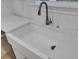 Close-up of a white farmhouse sink with sleek faucet and quartz countertops at 3027 Robeson Trce, Johns Island, SC 29455