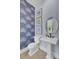 Stylish bathroom with a pedestal sink, framed pictures, wallpaper, and a round mirror enhancing the aesthetic appeal at 3041 Robeson Trce, Johns Island, SC 29455