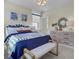 Well-lit bedroom with stylish decor, including a blue bedding, natural fiber bench, and tasteful wall art at 3041 Robeson Trce, Johns Island, SC 29455