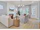 Cozy living room with a modern fireplace, large windows, comfortable seating, and light hardwood floors at 3041 Robeson Trce, Johns Island, SC 29455