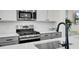 Close-up of a kitchen with stainless steel appliances, white countertops, and a black faucet at 422 Caledon Ct, Johns Island, SC 29455