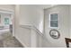 Carpeted staircase with white railing offers sunlit landing and open view to the living space at 422 Caledon Ct, Johns Island, SC 29455