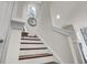 Traditional staircase with wood treads, white risers, and trim, bathed in natural light from nearby window at 422 Caledon Ct, Johns Island, SC 29455